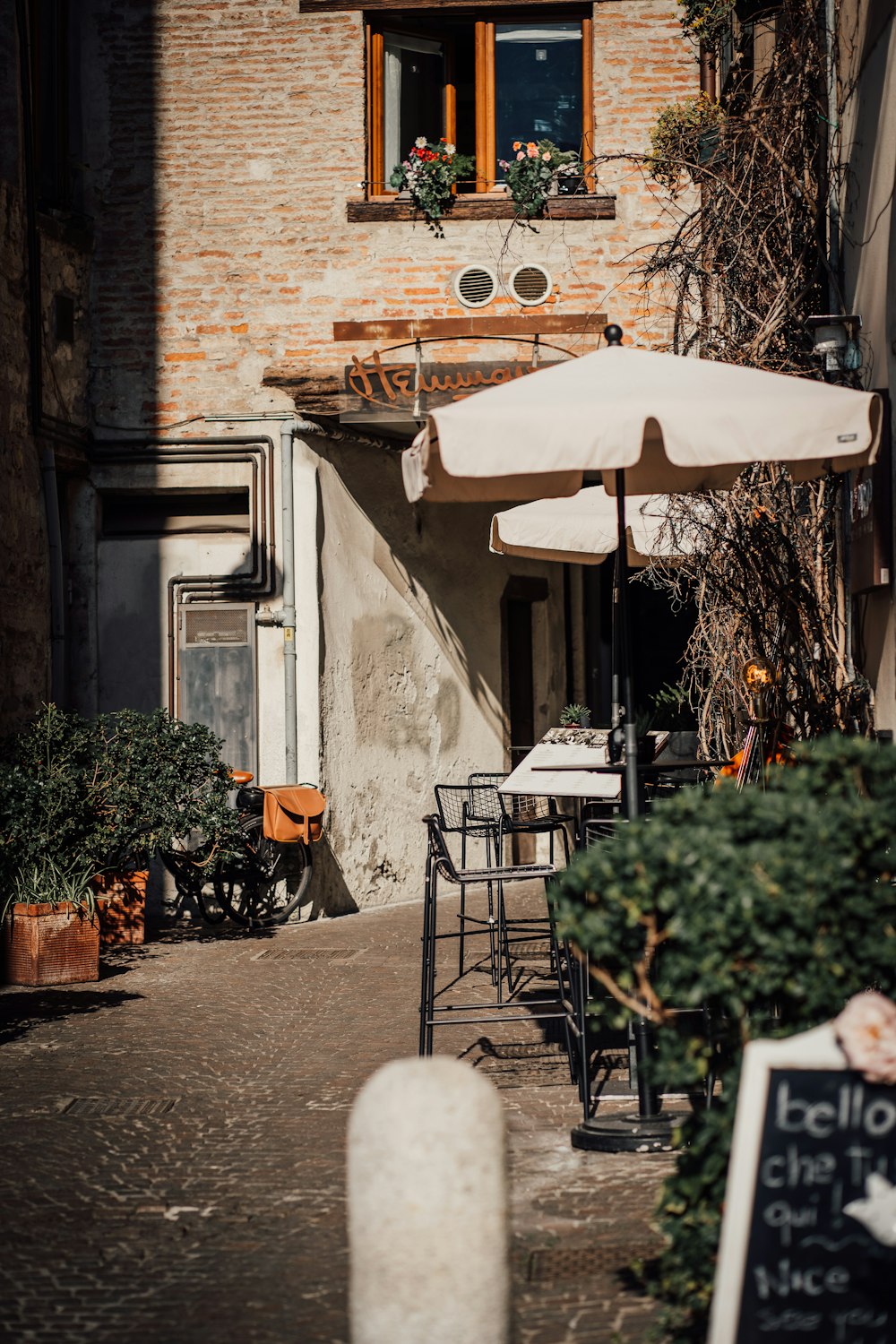 an outdoor cafe with tables and umbrellas