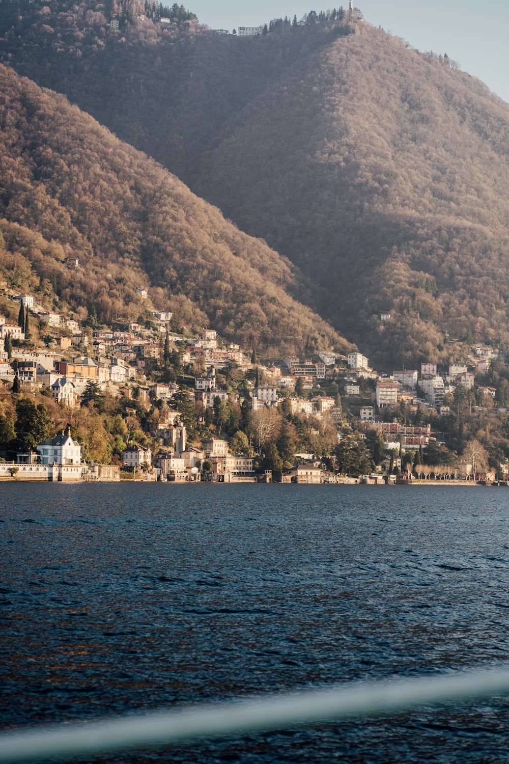 a body of water with houses on a hill in the background