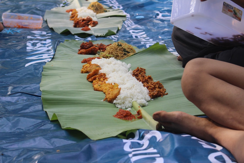 a group of people sitting on top of a banana leaf