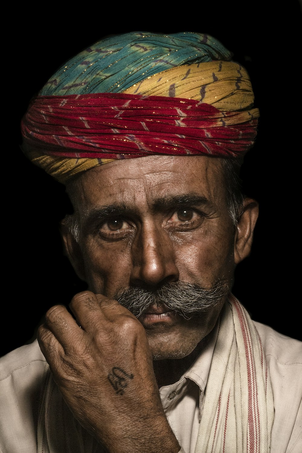 a man with a mustache and a colorful turban