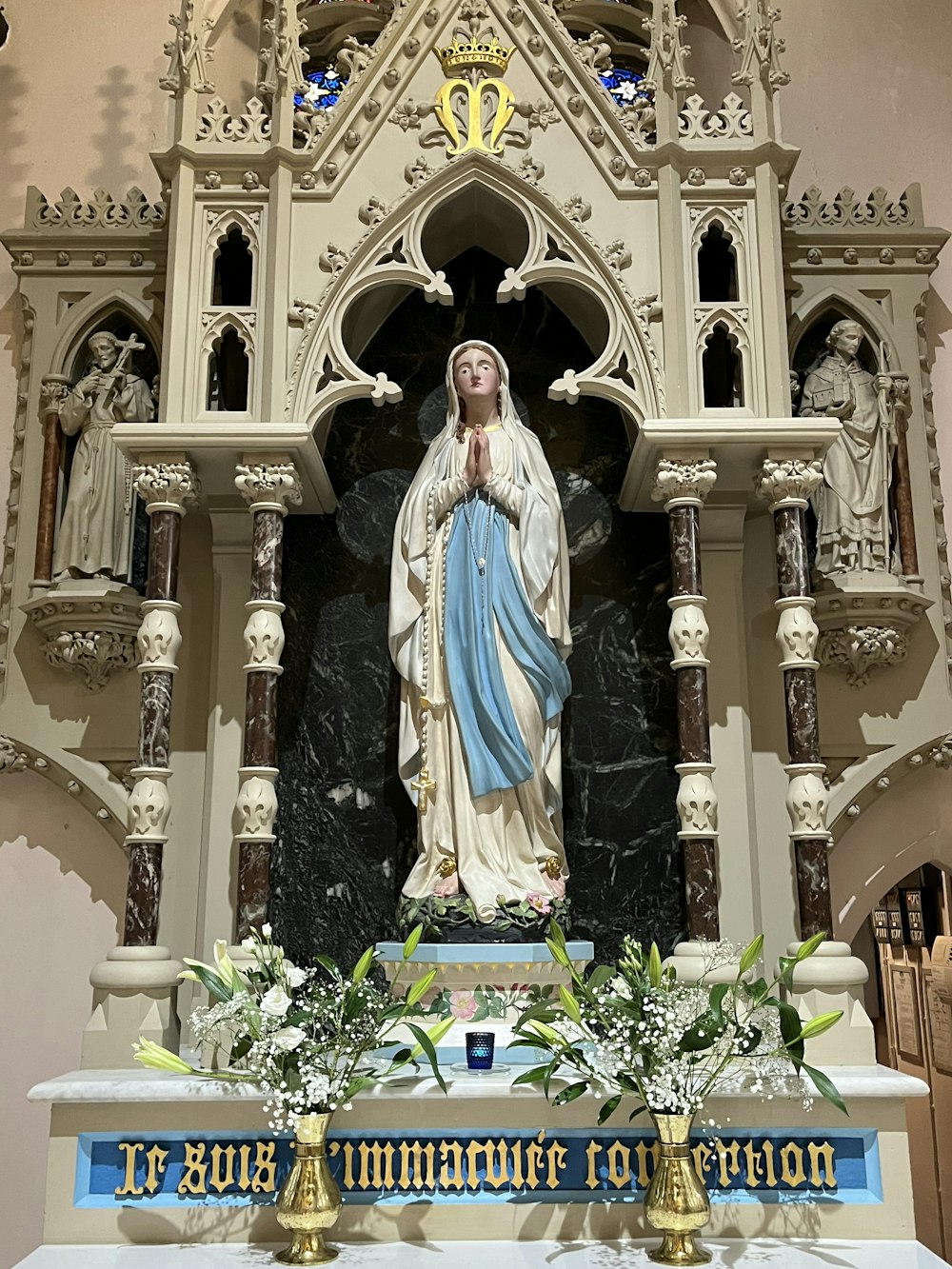a statue of the virgin mary in front of a church