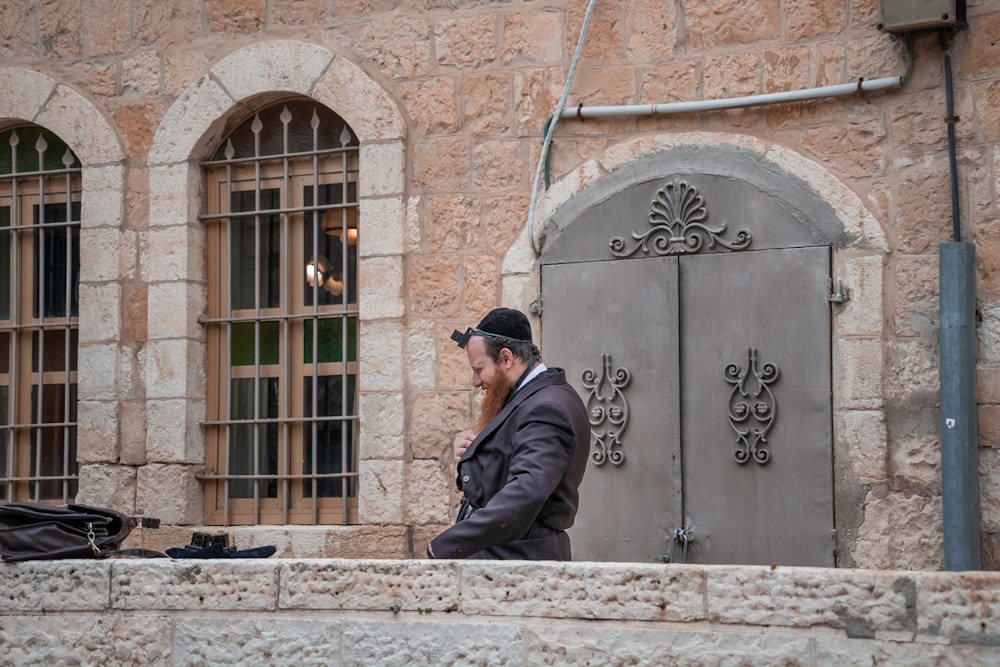 a man standing in front of a brick building