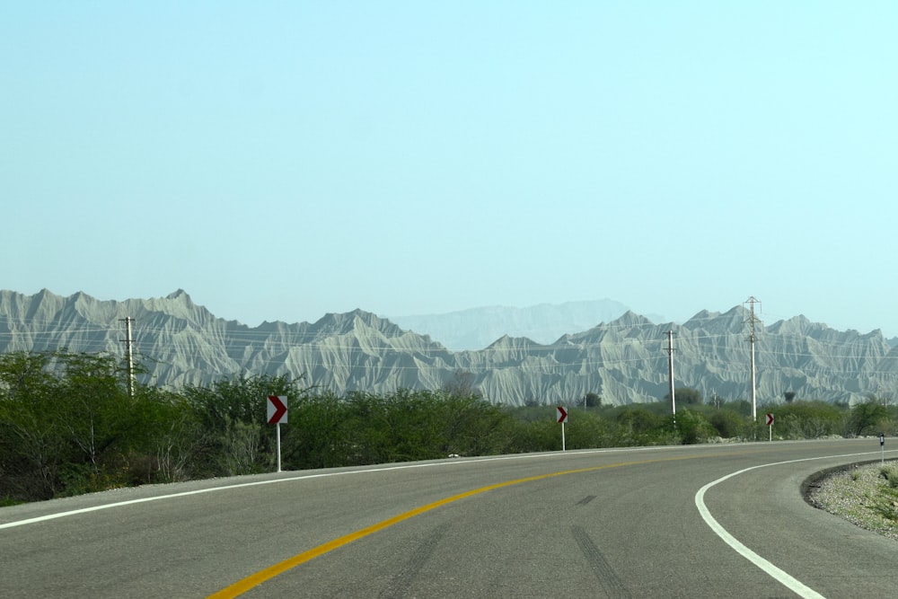 a curved road with mountains in the background