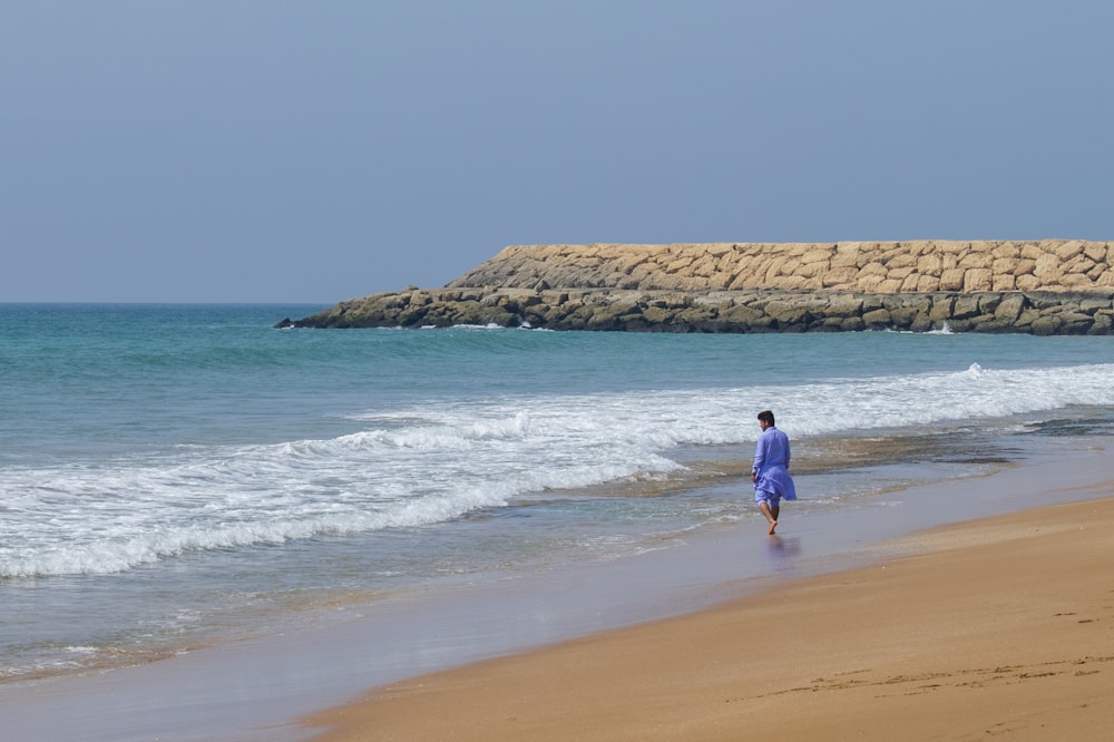 a person walking on a beach near the ocean