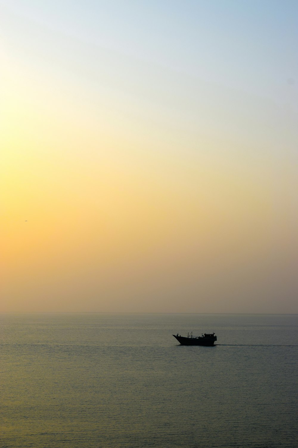 Una barca è fuori nell'oceano al tramonto