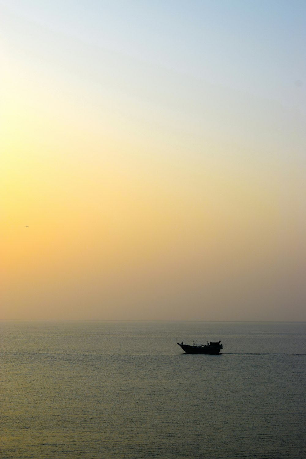 a boat is out in the ocean at sunset