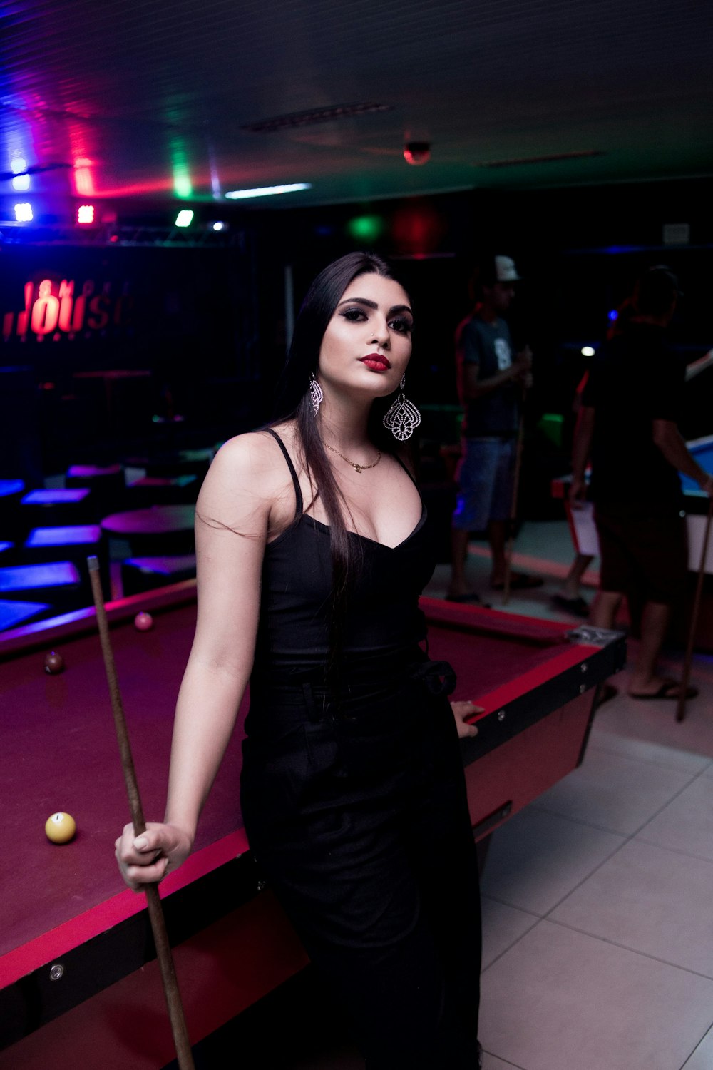 a woman standing next to a pool table