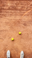 An image showing a tennis match taking place on a clay court.