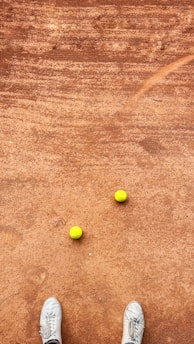 An image showing a tennis match taking place on a clay court.