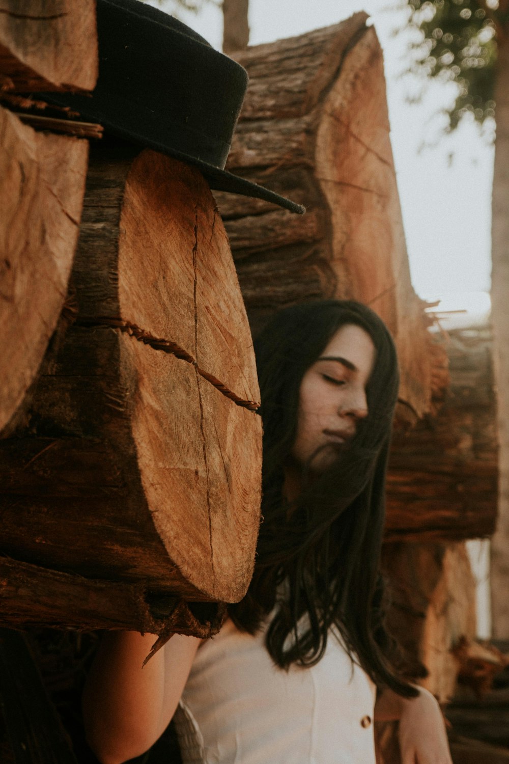 a man standing next to a pile of logs