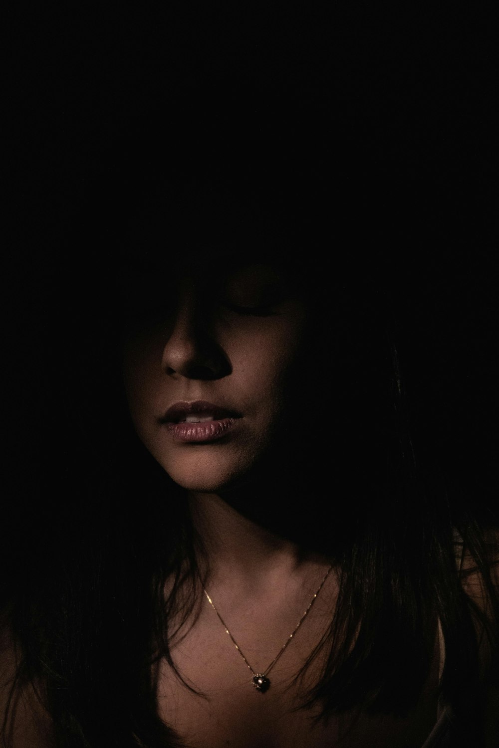 a woman with her eyes closed in the dark