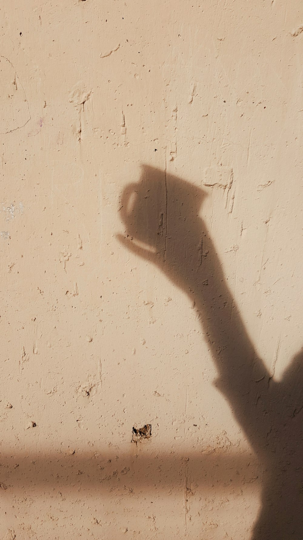 a shadow of a person holding a cell phone