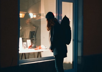 a person standing in front of a window at night