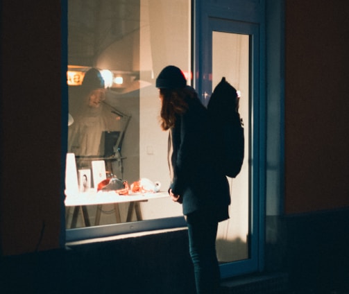 a person standing in front of a window at night