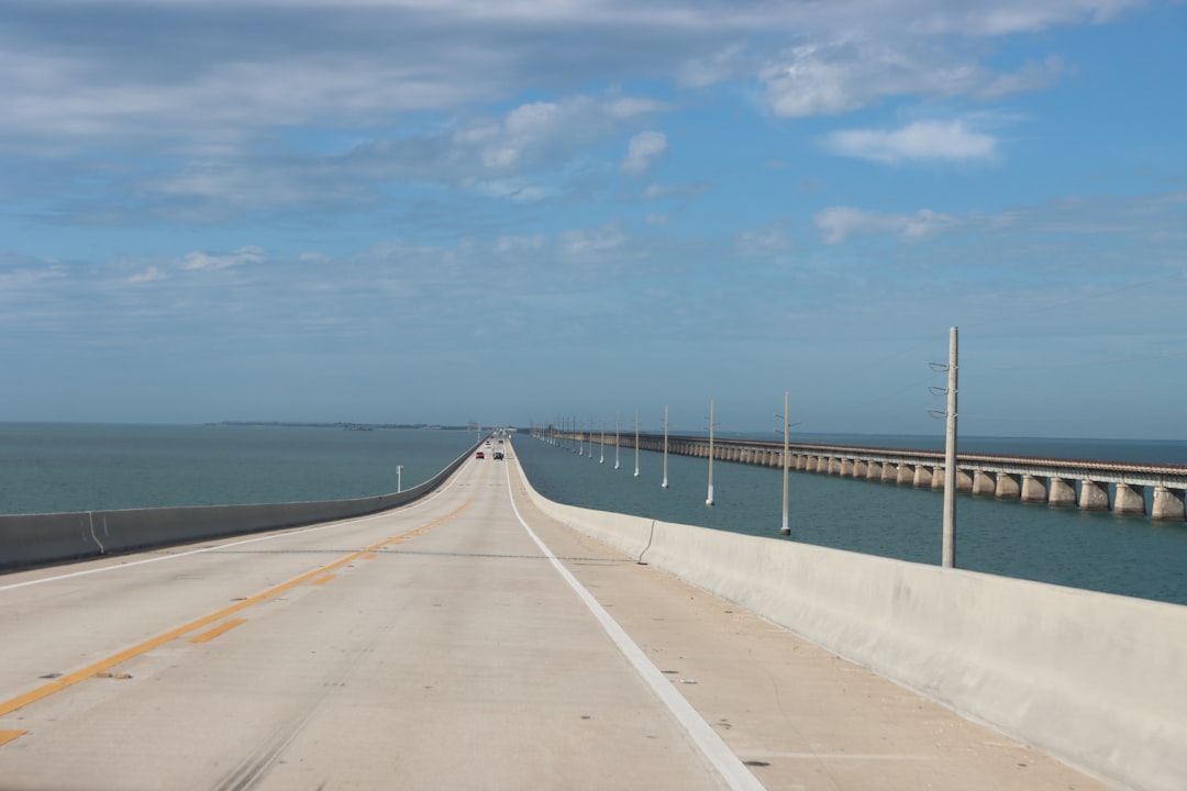 a long stretch of highway next to a large body of water,