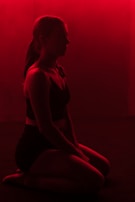 A silhouette of a submissive figure kneeling, bathed in warm, moody lighting that suggests reverence and surrender.