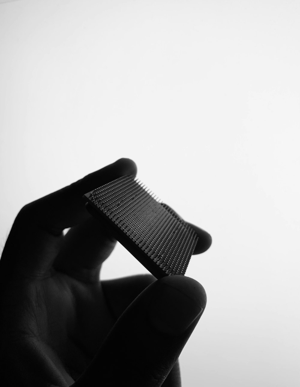 a black and white photo of a person holding a comb