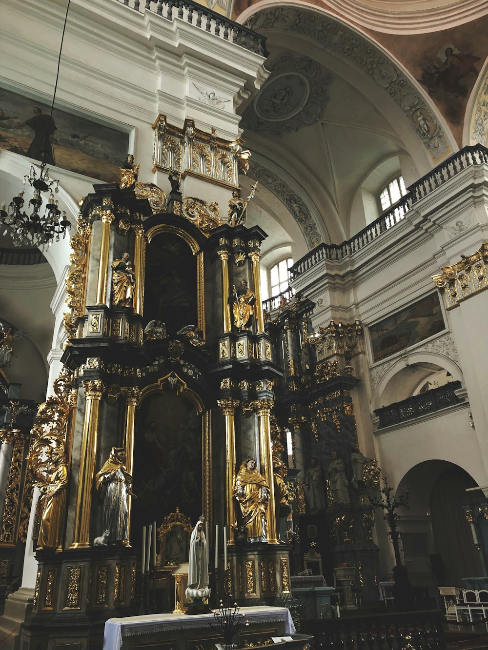 a gold alter in a church with a clock on the wall