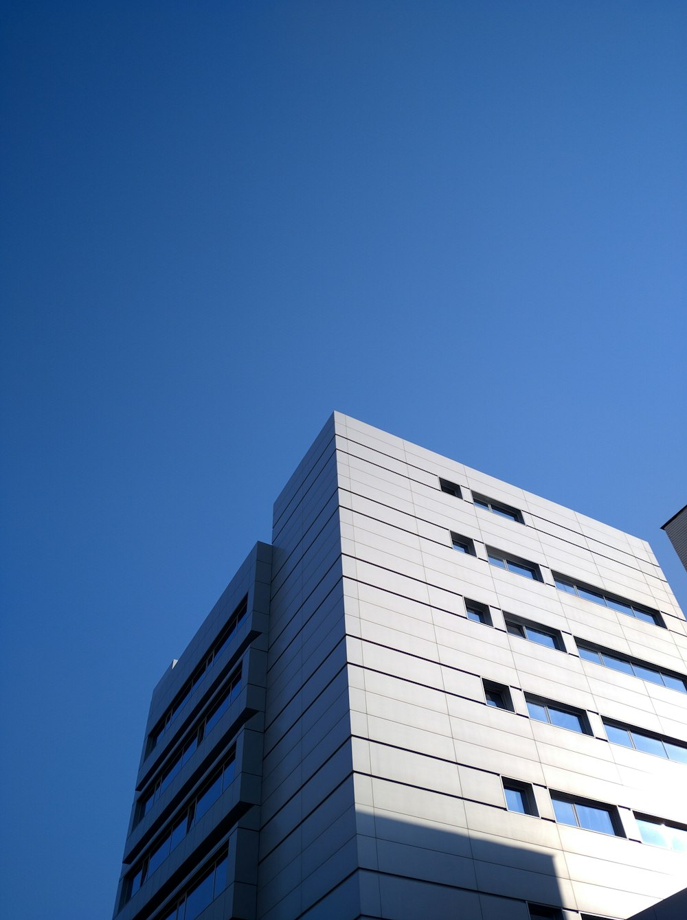 a tall white building with a sky background