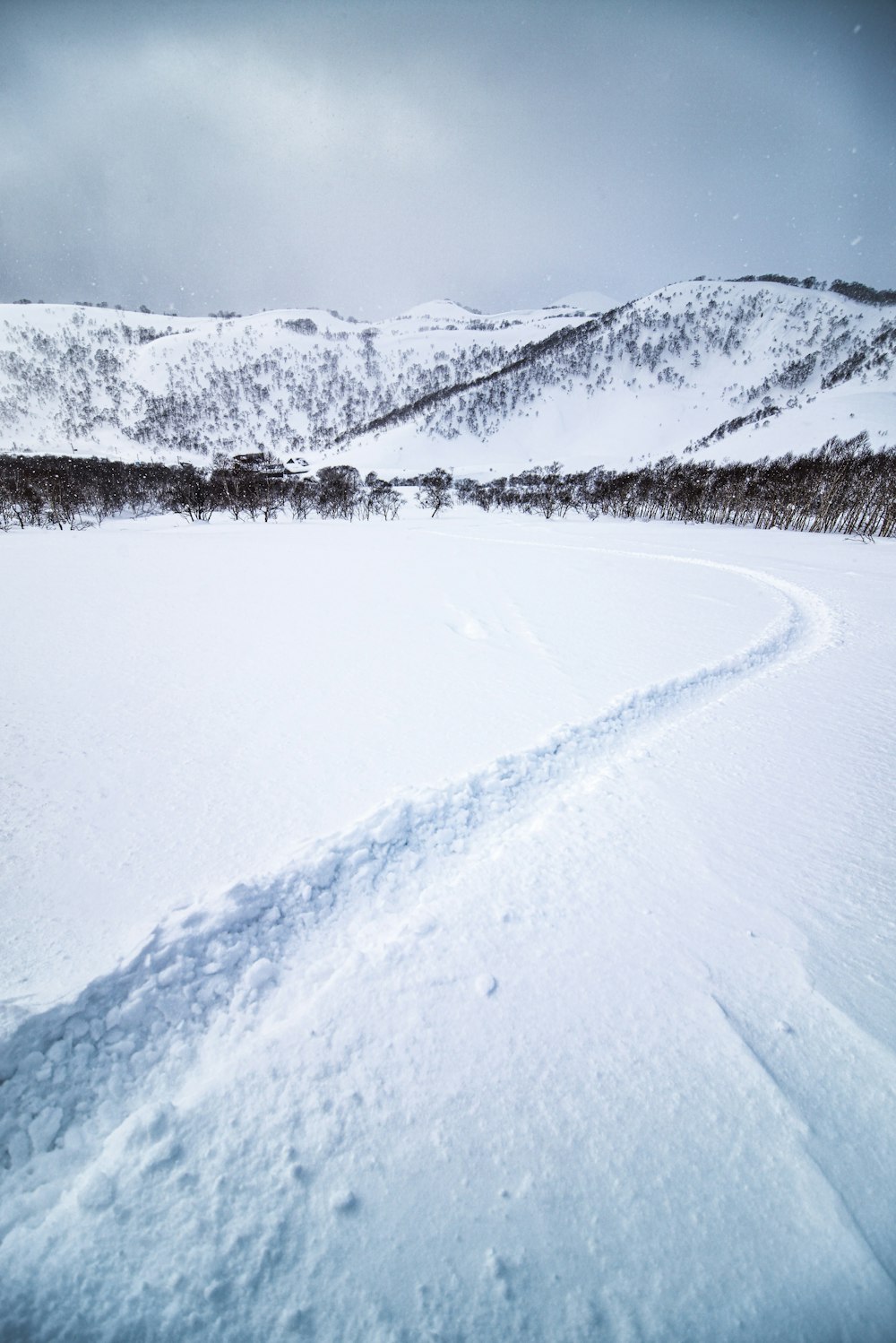 a man riding a snowboard down a snow covered slope