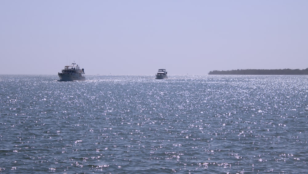 a couple of boats floating on top of a large body of water