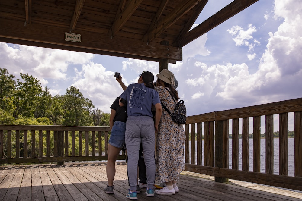 a group of people standing on top of a wooden deck