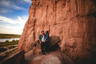 Happy couple laughing as they record a message on the guestbook, with the iconic red desert landscape behind them.
