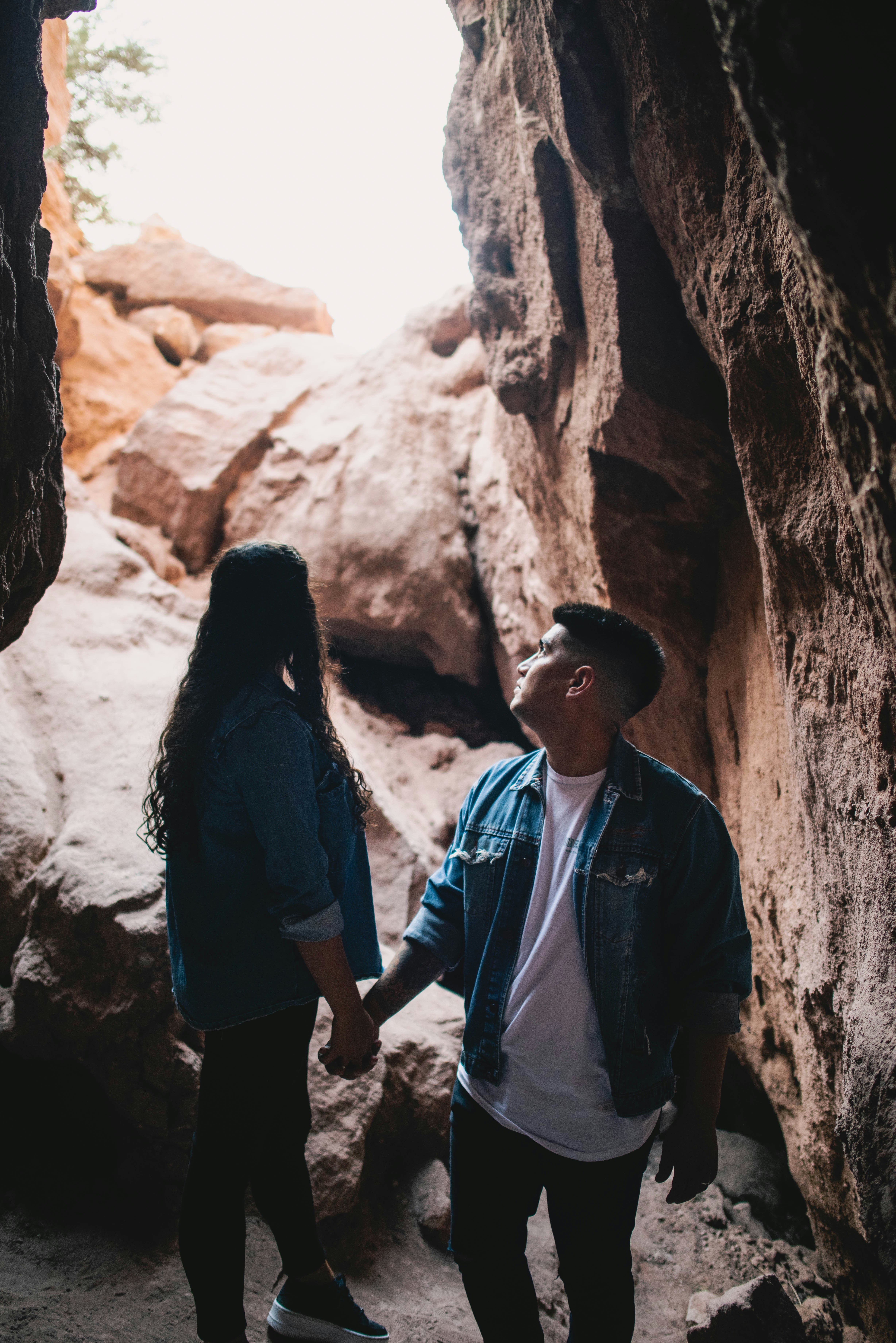 a man and a woman holding hands in a cave
