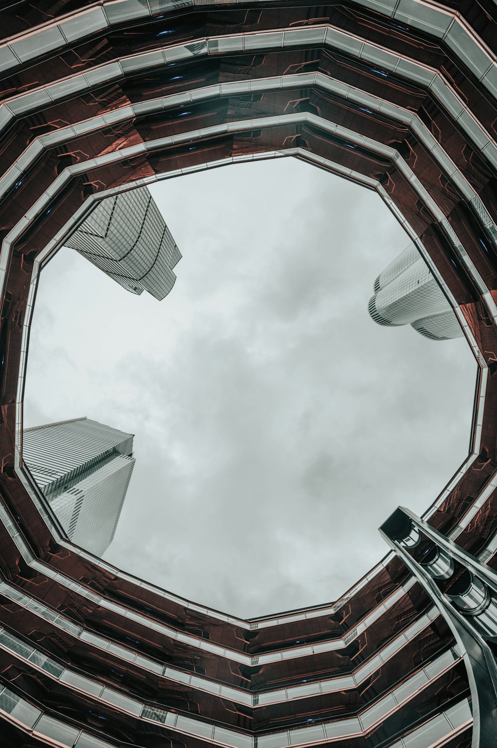 looking up at a circular building with a sky background