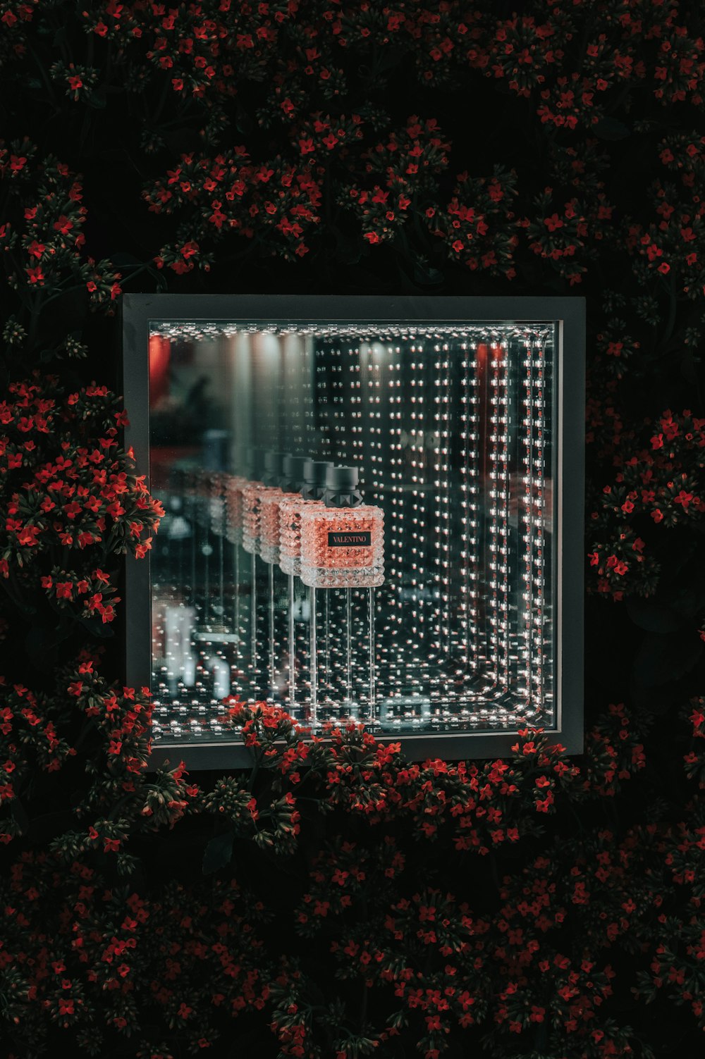 a picture of a building with red flowers around it