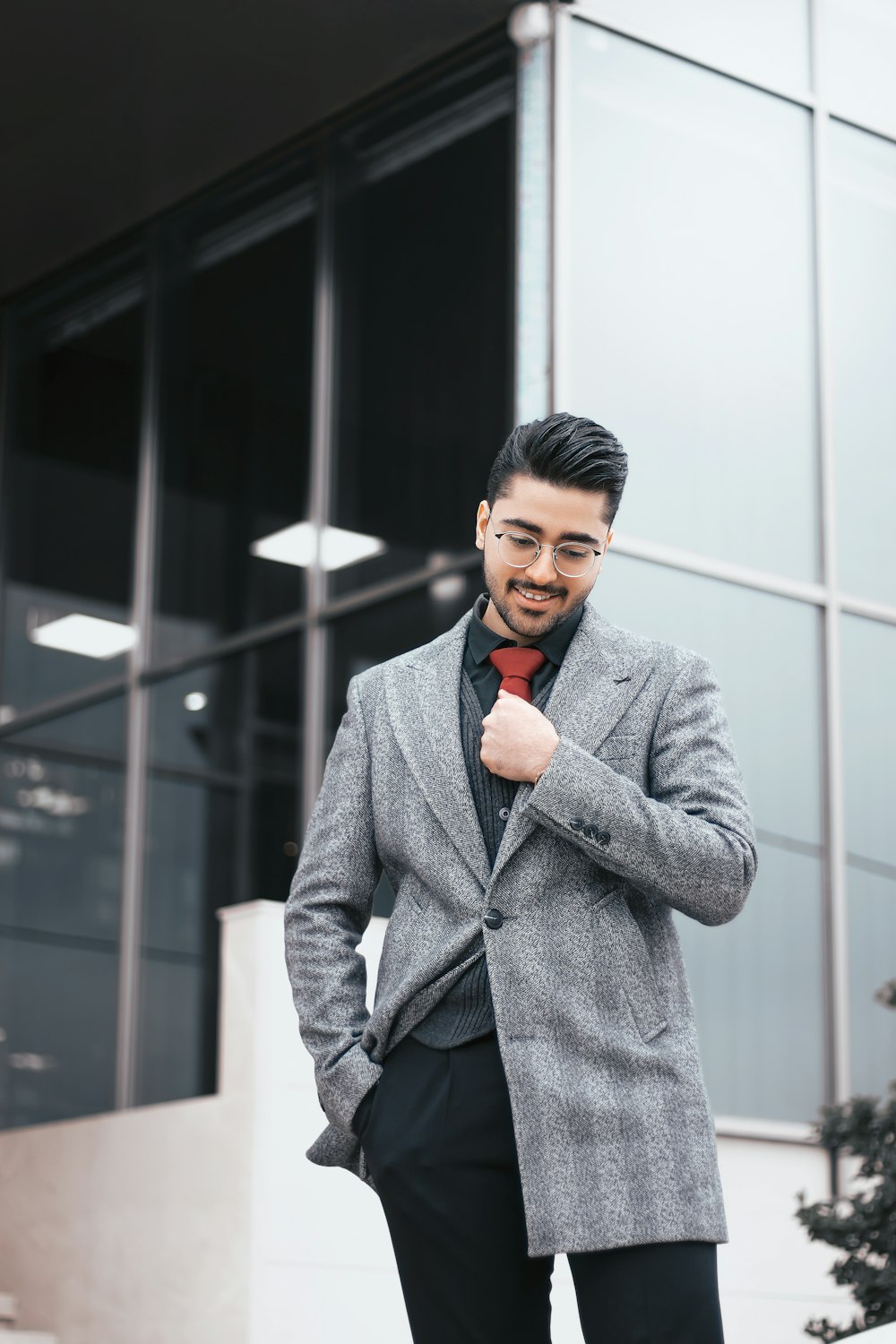 a man in a suit and tie standing outside of a building