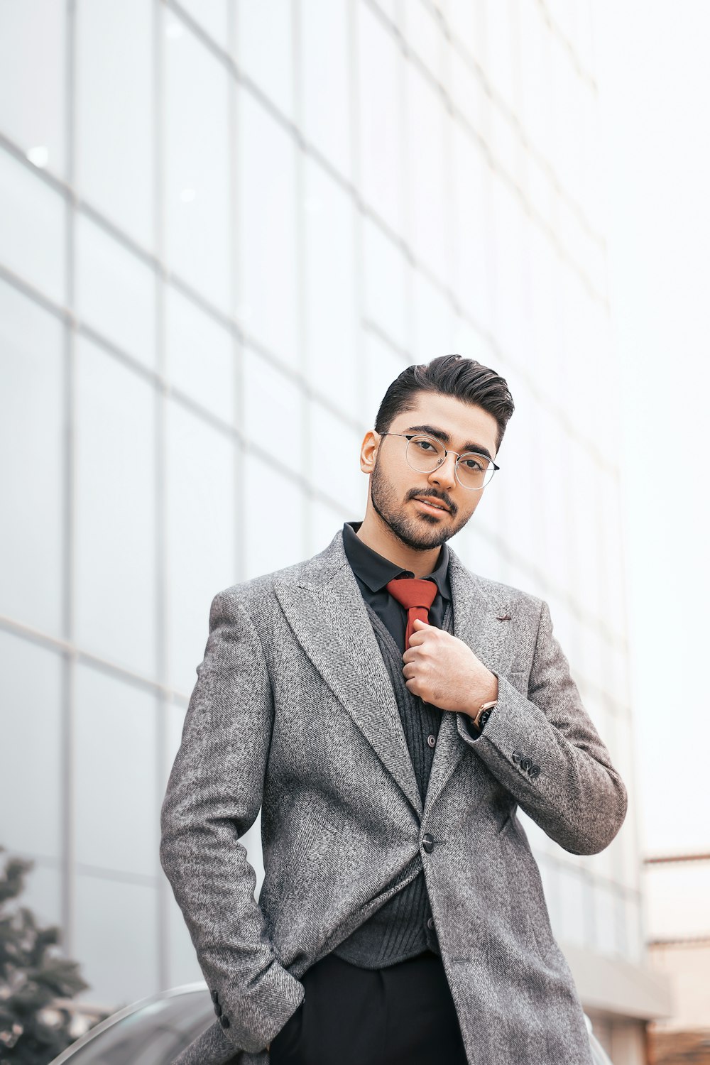 a man in a suit and tie standing in front of a building