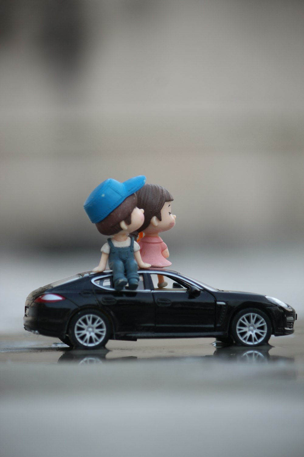 a toy car with a boy and a girl sitting on top of it