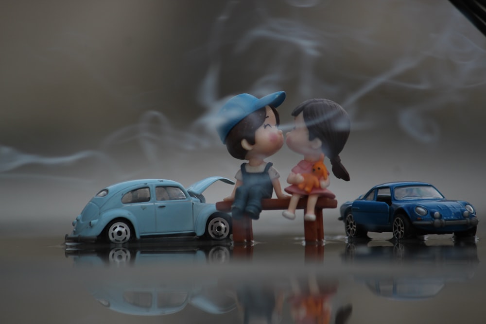 a couple of figurines that are next to a car