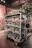A rolling utility cart with shelves loaded with gardening supplies in a bright garage.