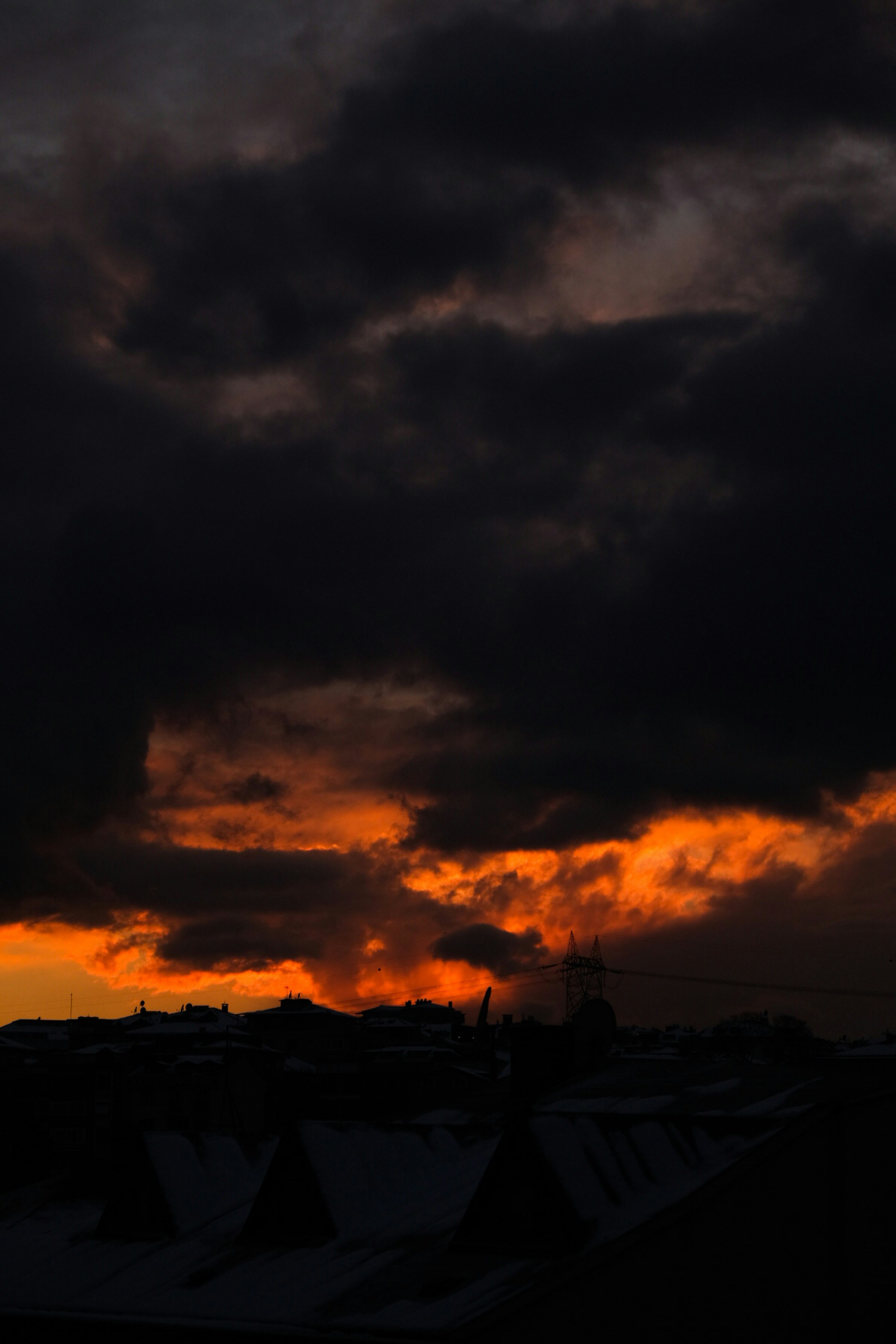 a plane flying in the sky with a sunset in the background