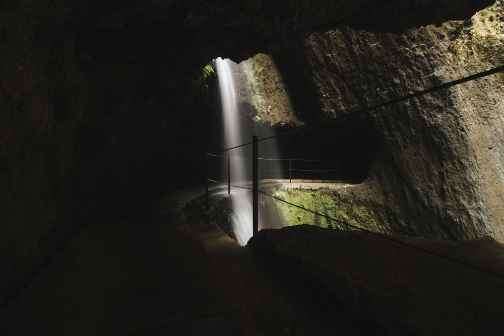 Una cueva oscura con una cascada que sale de ella