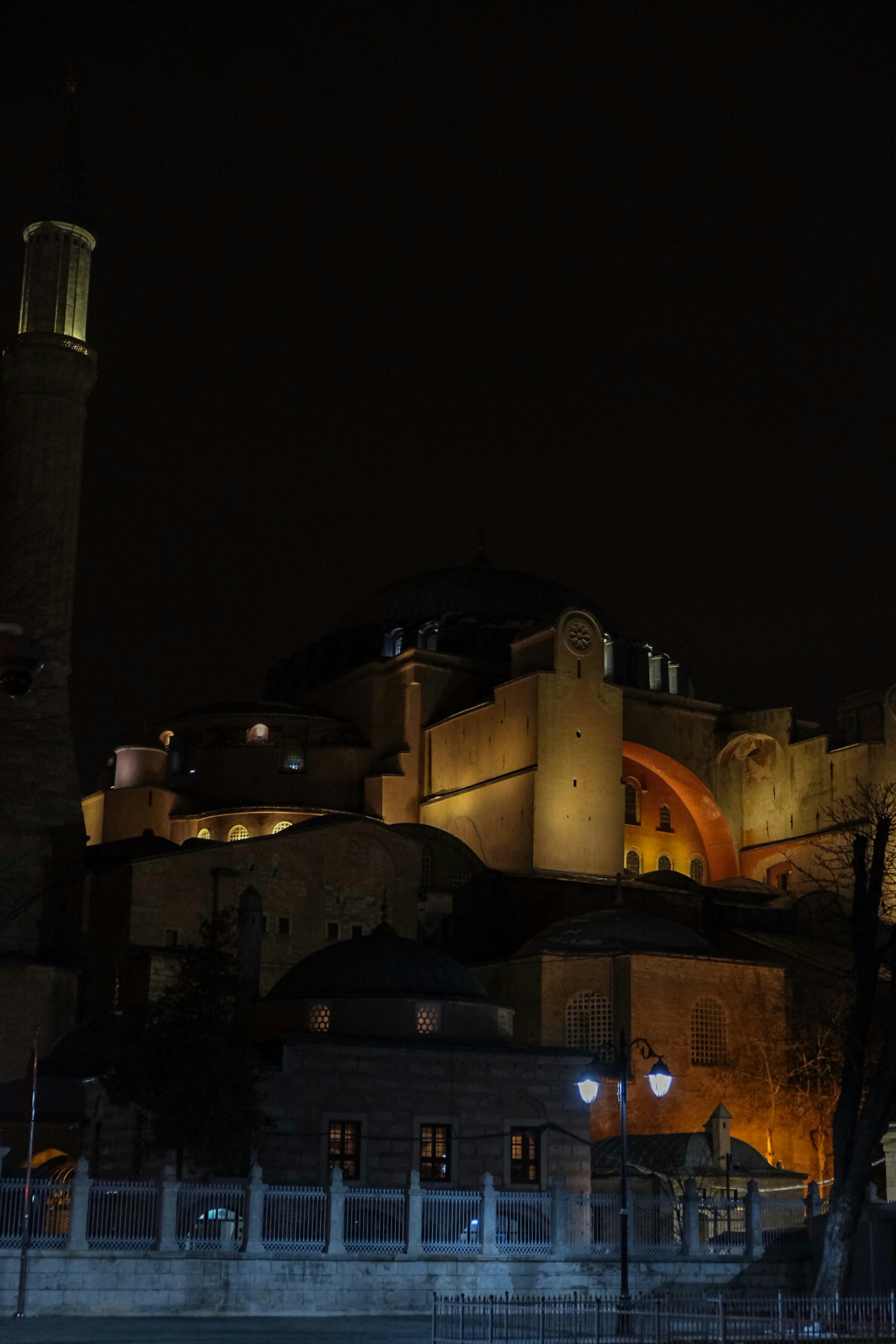 a building lit up at night with a clock tower in the background