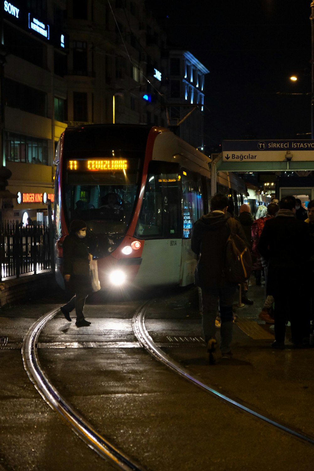 a bus driving down a street next to a crowd of people