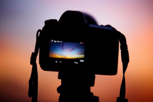a camera with a blurry background of a sunset