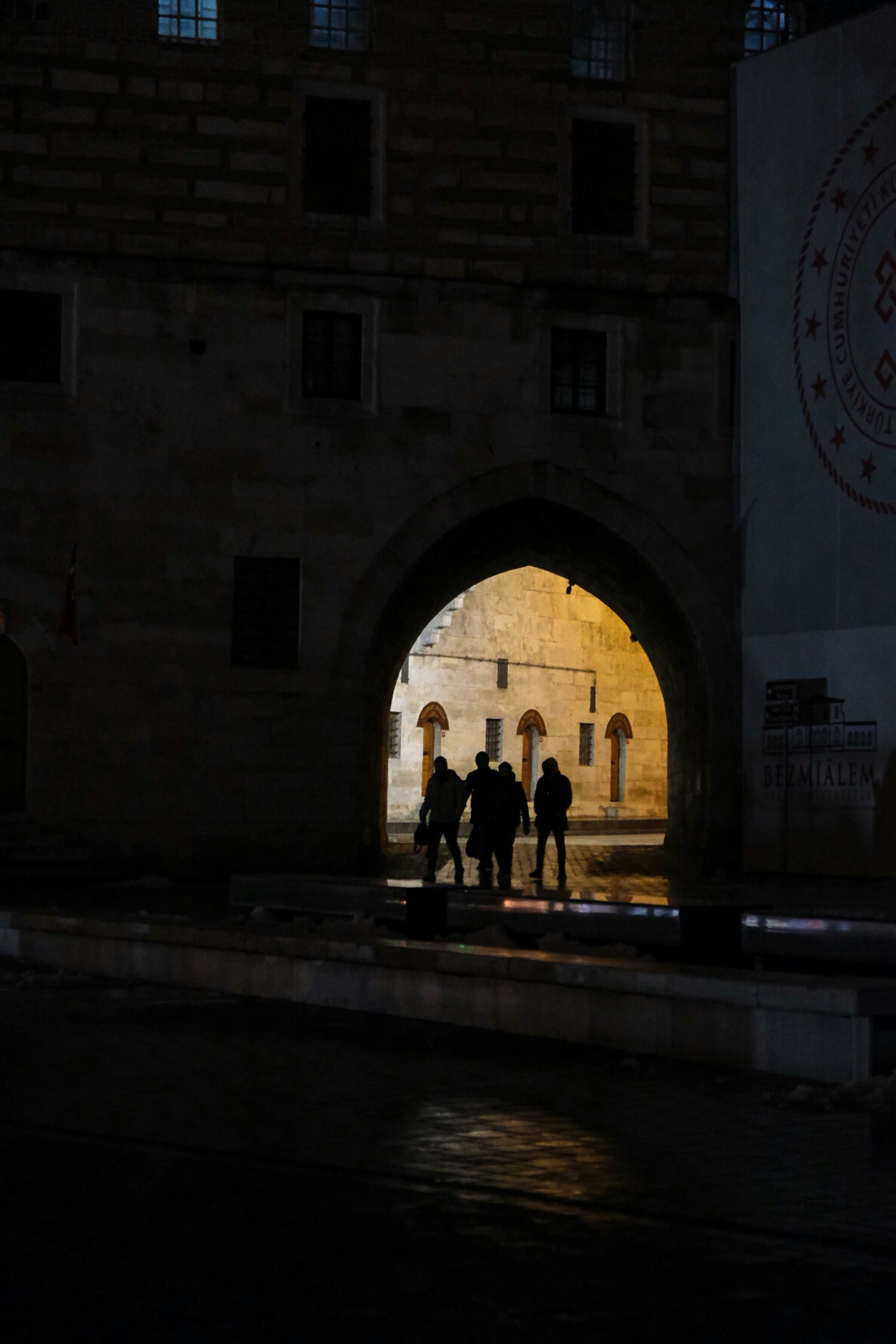 a group of people standing under a bridge at night
