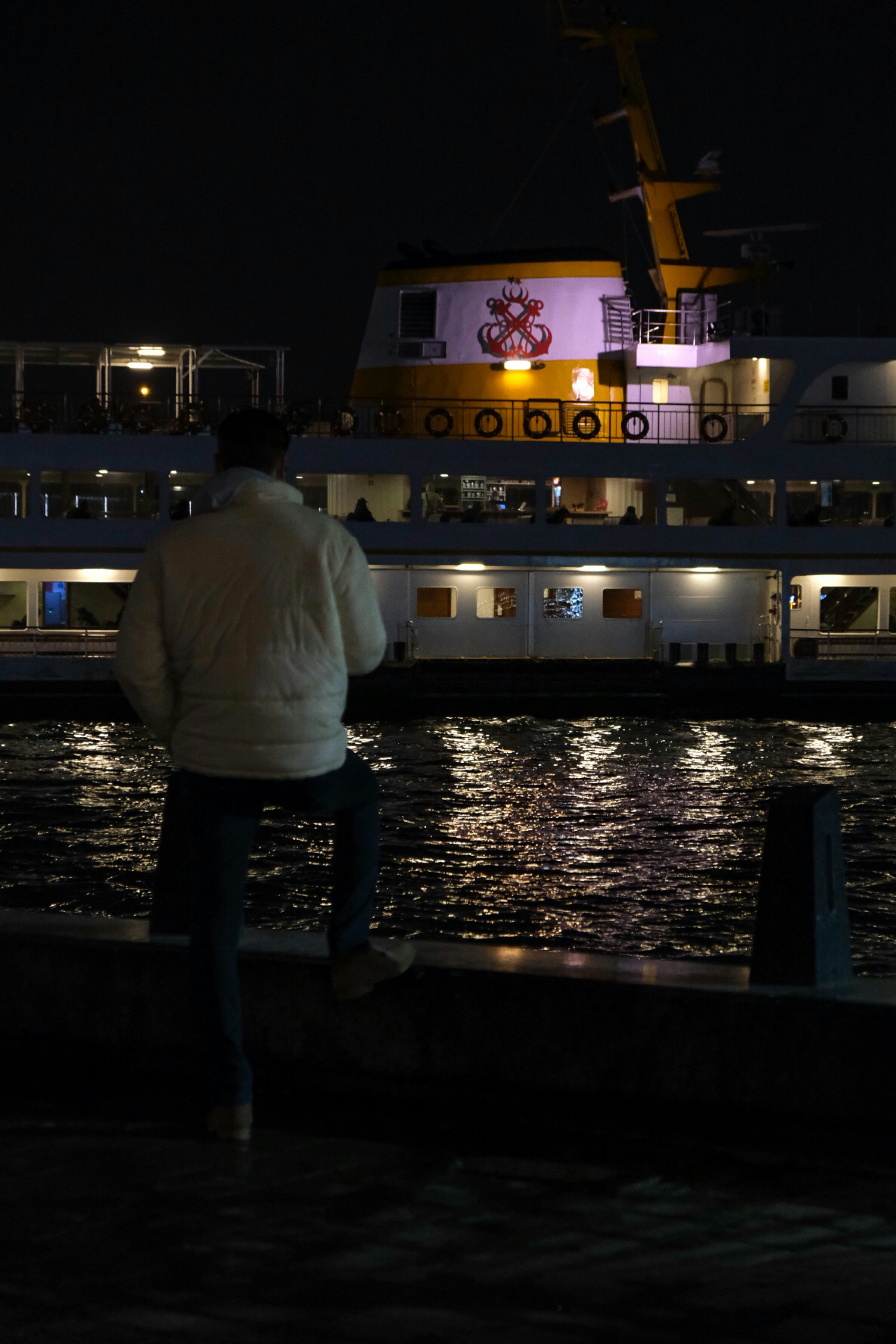 a man standing next to a boat at night