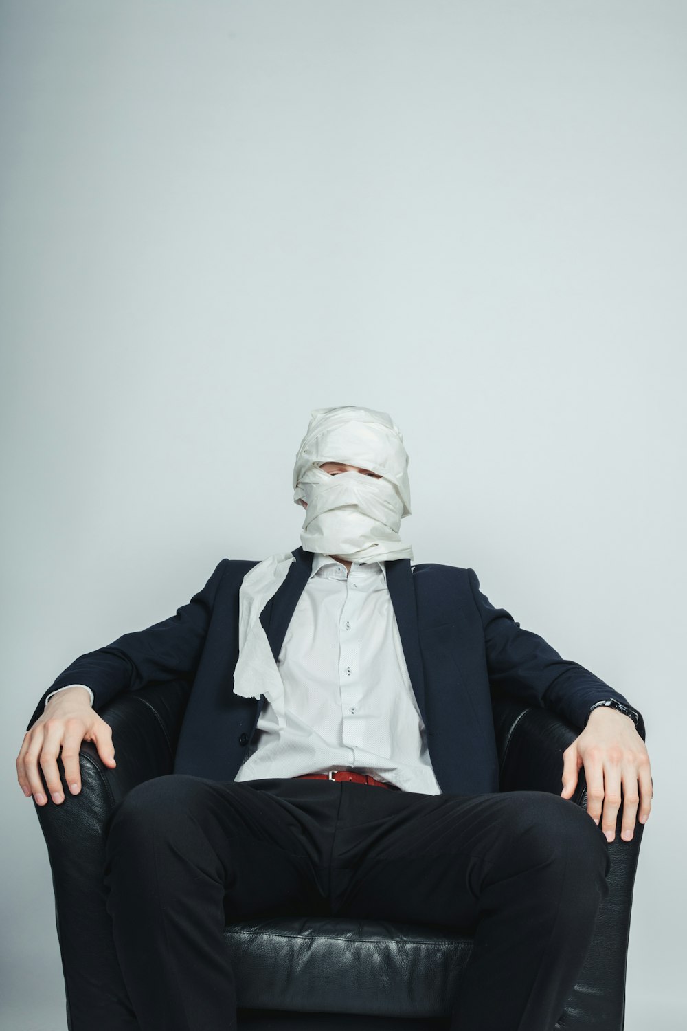 Un homme assis sur une chaise avec un masque sur le visage