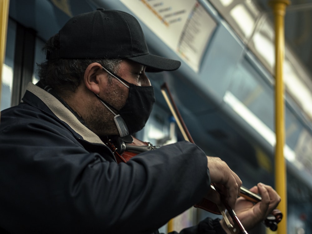 a man wearing a face mask and playing a guitar