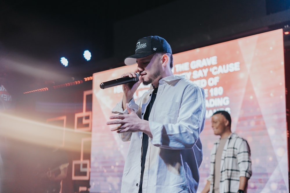 a man standing on a stage holding a microphone