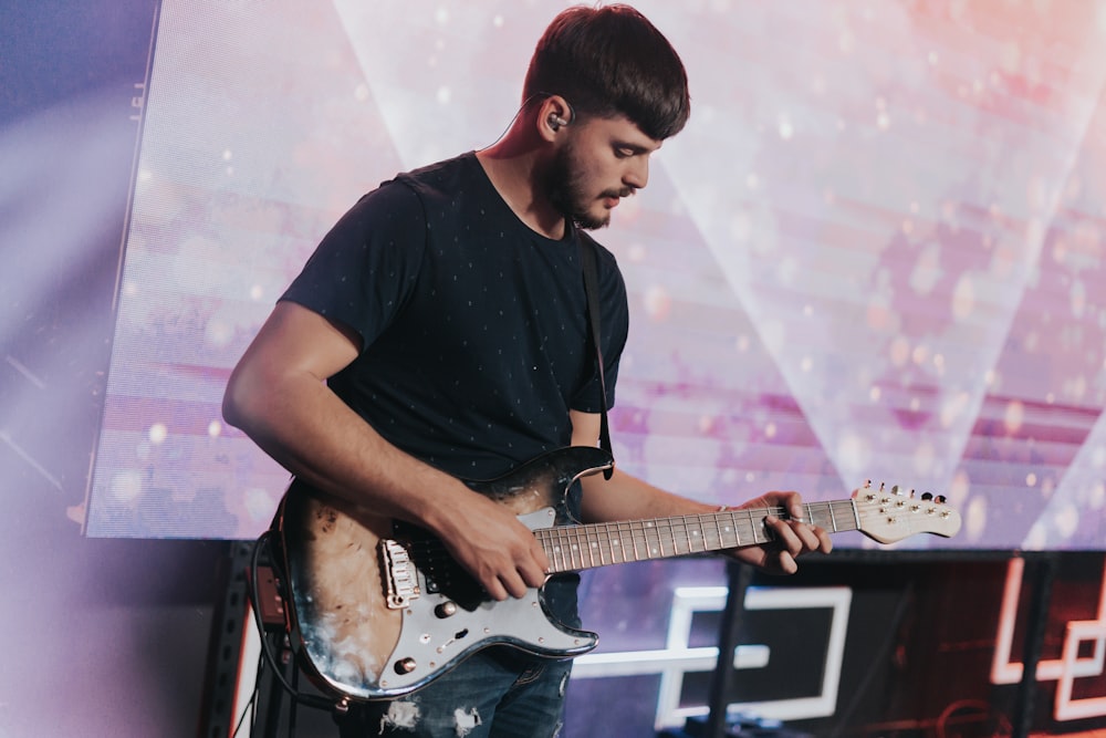 a man playing a guitar on a stage