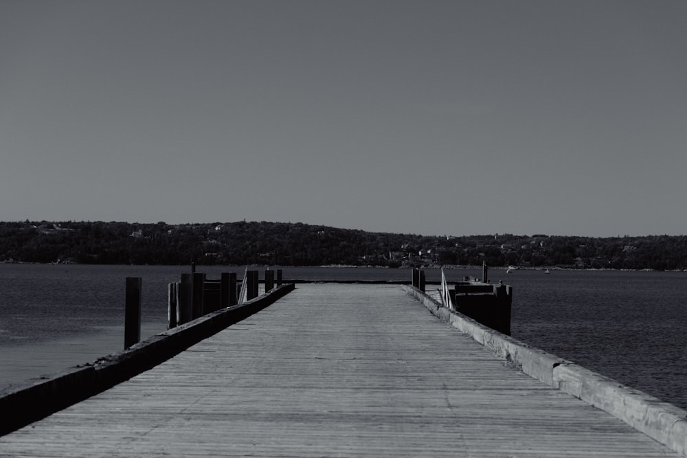 a black and white photo of a long pier