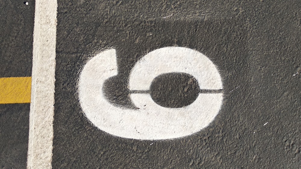 a white circle painted on the ground next to a yellow line