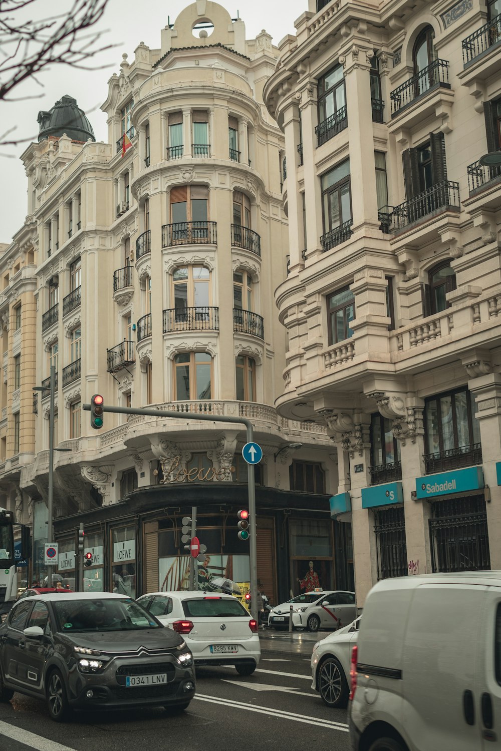 a city street filled with lots of traffic next to tall buildings