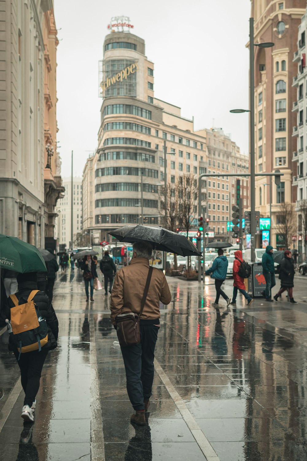 Un uomo che cammina lungo una strada tenendo un ombrello